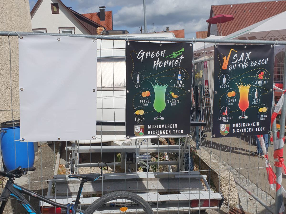 Drei Banner am Bauzaun: ein leeres, „Green Hornet“ mit Trompete und „Sax on the Beach“ mit Saxophon