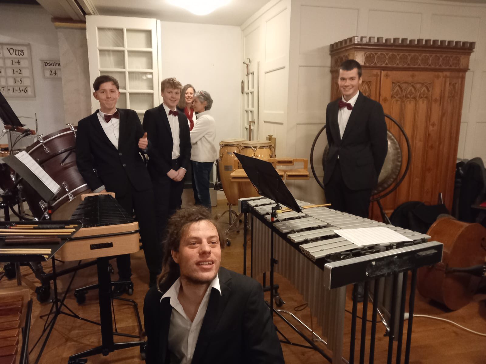 Das Schlagwerk mit Vibraphon, Xylophon, Pauken und Gong vor der Liedtafel, einer zeigt den Daumen hoch