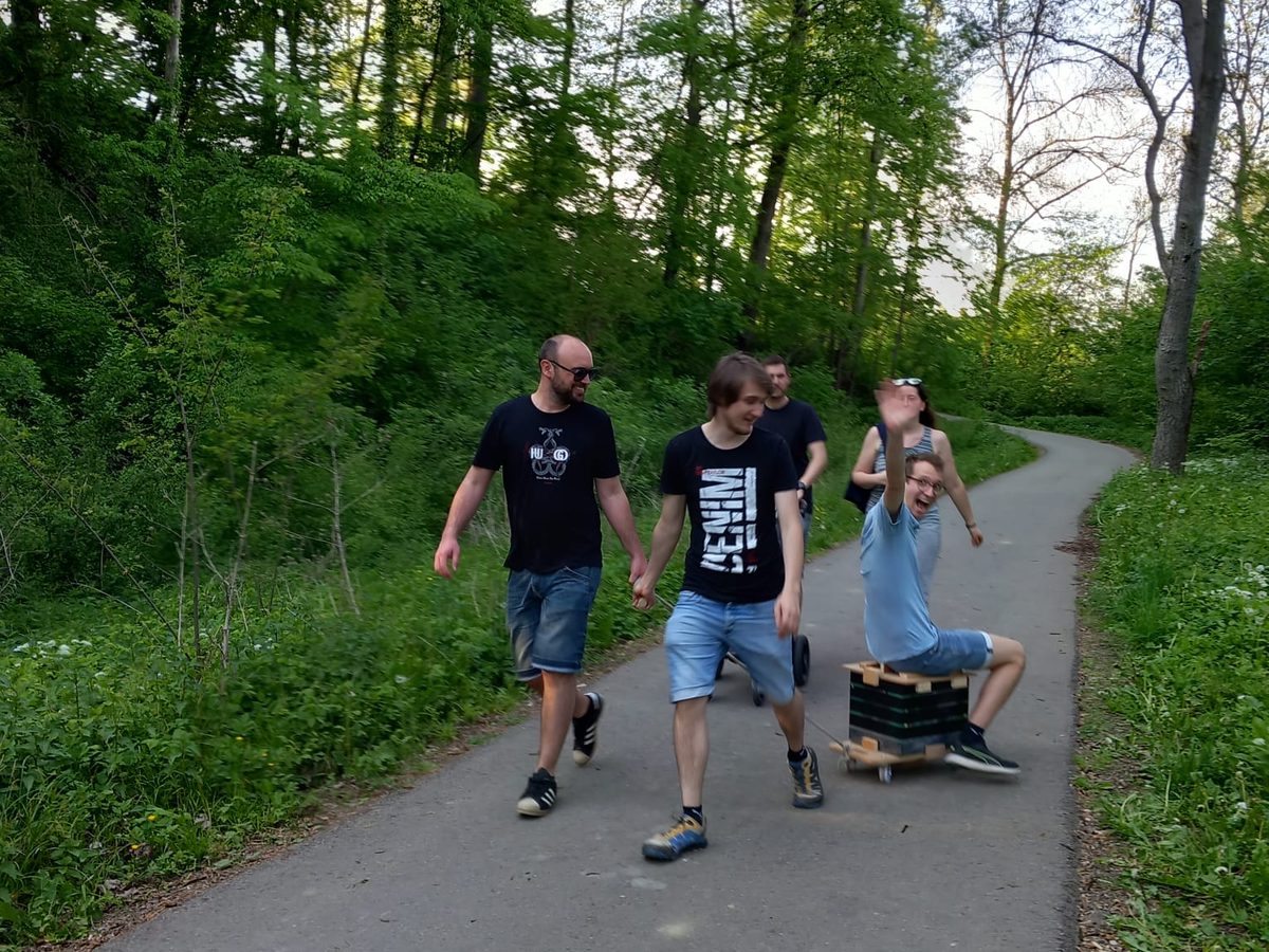 Einer fährt auf dem Bollerwagen mit, zwei ziehen