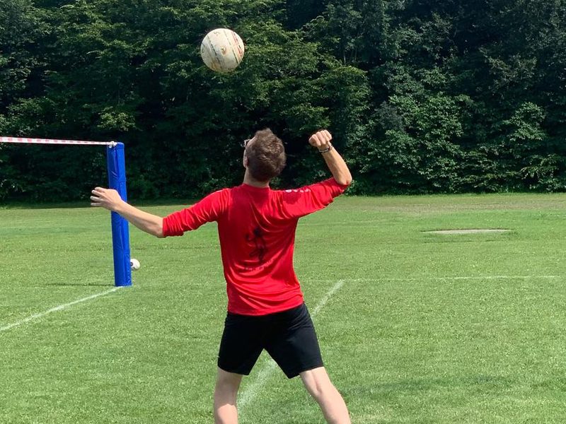 Ein Spieler schlägt auf, der Ball fliegt